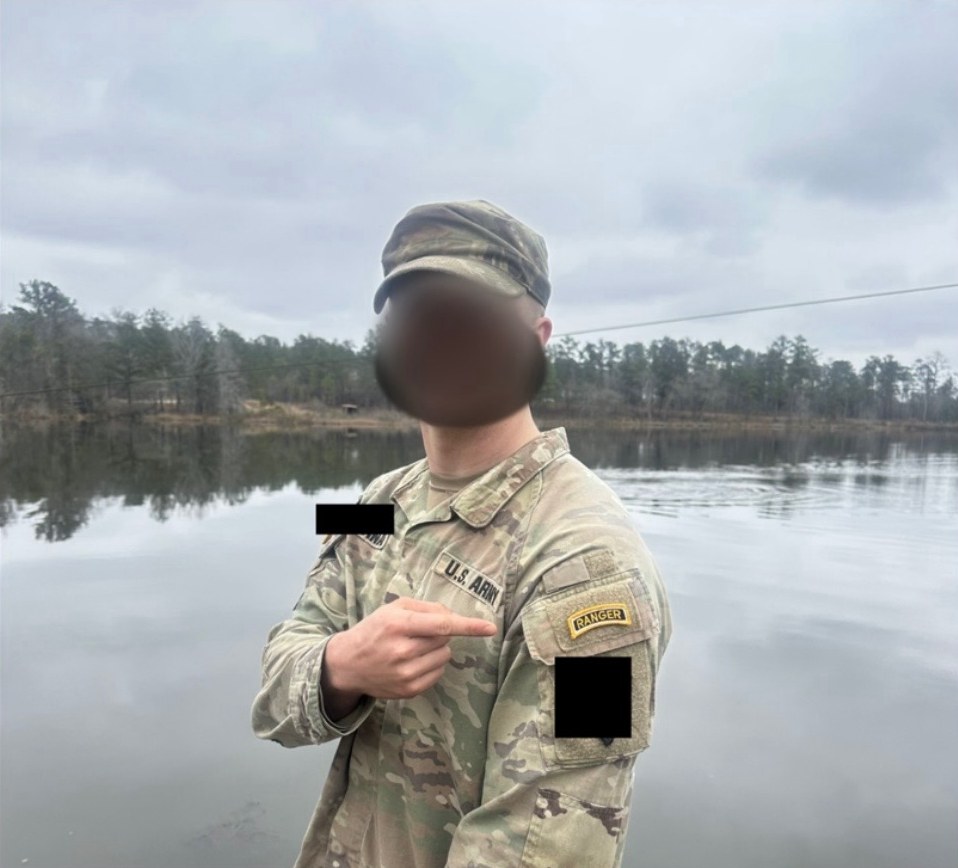 Ranger Ready founder by a lake, pointing to the Ranger tab on his shoulder